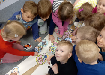 dzieci ozdabiają postać z papieru